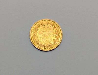 une image représentant une pièce d'or posée sur une surface grise