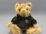 a teddy bear that is wearing a black jacket