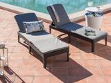 deux chaises longues et une table près d'une piscine