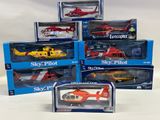 six assorted toy helicopters in boxes on a white surface