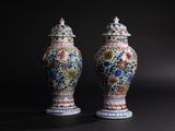 pair of chinese vases with floral designs on them against a black background