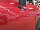 a close up of a red car with a sticker on it