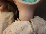a close up of a doll ' s head with a doll in the background
