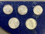 six pièces différentes sont disposées sur un plateau bleu à fond blanc