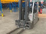 a forklift in a large warehouse with lots of pallets