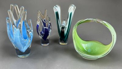 quatre vases en verre de couleurs différentes posés sur une table