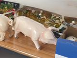 trois figurines de cochons posées sur une étagère dans une pièce