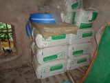 une pile de sacs de ciment posée sur une palette dans une pièce