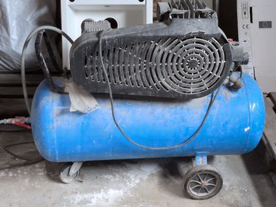 un compresseur d'air bleu posé sur un réservoir bleu