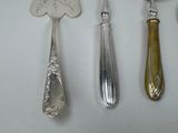 four spoons and a fork on a white surface