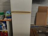 a white refrigerator sitting in the corner of a room