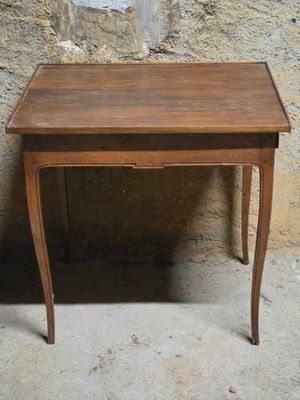 une petite table en bois sur laquelle se trouve un vase