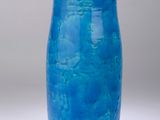 a blue vase that is sitting on a white surface