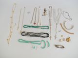divers colliers et bracelets disposés sur une surface blanche