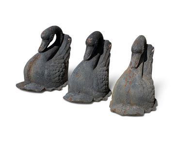 trois canards en fonte empilés les uns sur les autres sur une surface blanche