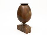 a wooden vase with a wooden base on a white background