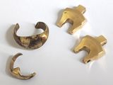 trois pièces en laiton sont représentées sur une surface blanche