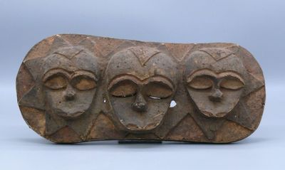 a close up of a stone object with three faces on it