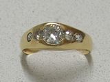 a gold ring with a diamond on it on a table