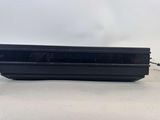 une console de jeux vidéo noire posée sur une table blanche