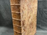 an old book sitting on top of a table with a piece of paper sticking out of it