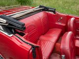 a red convertible car with leather seats and a gun in the back