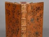 un vieux livre à la couverture brune posé sur une table