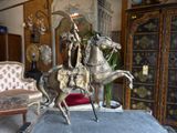 a statue of a man riding a horse in a living room