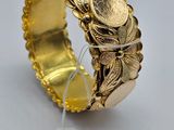 Gros plan sur un bracelet en or orné de pièces de monnaie