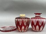 two red glass vases sitting next to each other on a table