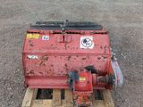 a red tank sitting on a pallet in the dirt