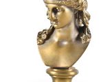 bronze bust of a woman on a pedestal on a white background