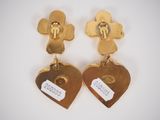 pair of gold tone flower and heart shaped earrings with tags