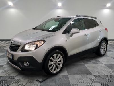 Le SUV Buick blanc est garé sur un sol en carrelage à damier.