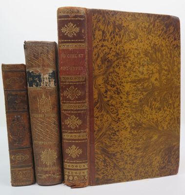 three old books sitting on top of each other on a white surface