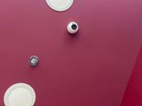 a picture of a bathroom with a toilet and a red wall