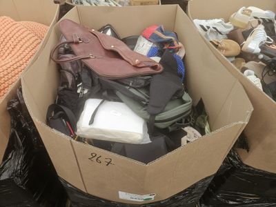 une boîte remplie de chaussures et de sacs posée par terre