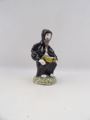 une petite figurine représentant un homme assis sur un tabouret