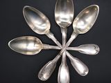 six silver spoons arranged in a circle on a black surface