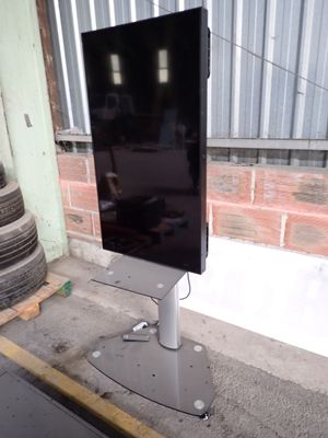 a flat screen tv sitting on a stand in front of a building
