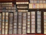 de nombreux livres anciens dans une boîte rouge posée sur l'étagère