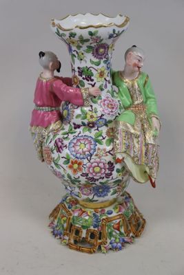 deux figurines posées sur un vase