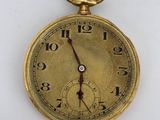 a gold pocket watch on a white surface