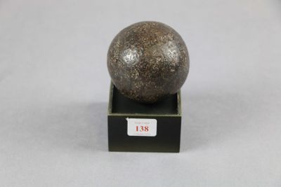 une image représentant une boule en pierre posée sur un socle noir