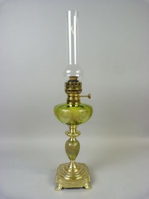 une image représentant une lampe en verre vert avec un pied doré