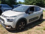 La voiture est garée dans l'herbe, à côté de nombreuses autres voitures.