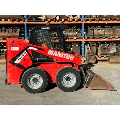 a picture of a red ski - loader parked in a warehouse