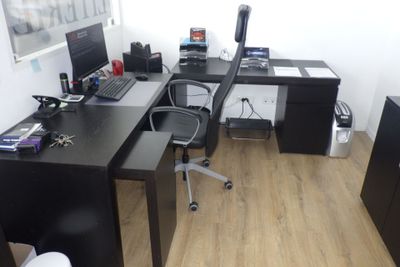 un bureau avec un ordinateur et une chaise dans une pièce