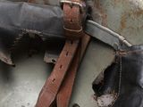 an old helmet with a leather strap and a pair of boots