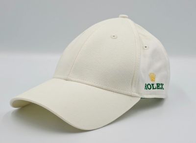 La casquette est blanche et porte un logo vert.